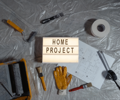 Home improvement project sign on a tarp surrounded by various tools.